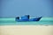 A blue working fishing boat on the sea close to the beach