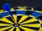 Blue, yellow dartboard and arrows hitting the target