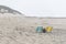 A blue and yellow folding chair on a beach