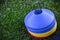 Blue and yellow football trick lies on the lawn closeup illuminated by sun