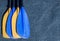 Blue and yellow paddle blades on the gray textured background. Look from the top