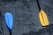 Blue and yellow paddles on the gray textured background laying on the left and right sides