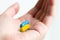 Blue and yellow pill on hand. Ukrainian Medical Capsules. Humanitarian medical care