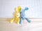 Blue and yellow rabbit doll laying on white bed under cream blanket pink polka dot pattern