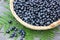 Blueberries bilberry in a basket on a wooden table, top view.