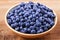 Blueberries in clay bowl. Freshly picked berries on rustic background.