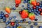 Blueberries Grape Strawberries Fruits on wooden plate on wooden background