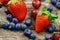 Blueberries Grape Strawberries Fruits on wooden plate on wooden background