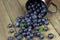 Blueberries in metal cup on wooden background