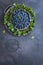 Blueberries and mint leaves in metal tray on a rustic surface