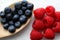 Blueberries and raspberries on shabby looking wooden table