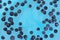 Blueberries sinking into blue water with air bubbles background