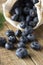 Blueberries spilling out of a brown textile, eco bag over rustic wood table. Zero waist concept, no plastic. Eco friendly berries