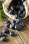 Blueberries spilling out of a brown textile, eco bag over rustic wood table. Zero waist concept, no plastic. Eco friendly berries