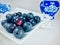 Blueberries on white square saucer.