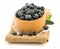 Blueberries in the wooden bowl with green leaves on the burlap c