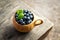 Blueberries in wooden kuksa mug. Cup of delicious blueberries stands on the wooden table.