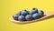 Blueberries in wooden spoon on yellow