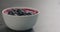 Blueberries in yogurt in white bowl on concrete surface
