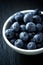 Blueberry, blueberries, fresh berry, berries, bilberry, bilberries served in a small ceramic bowl on black background.