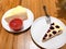 Blueberry Cheesecake and Crepe Cake with strawberry sauce are on the white dish. All were placed on the wooden table