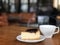 Blueberry Cheesecake and white coffee mug ready to served on wooden table in the coffee shop