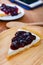 Blueberry cheesecake on wood plate.