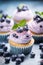 Blueberry cupcakes decorated with lavender frosting, blueberries and mint