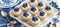 Blueberry mini tart on white cutting board with vintage teaspoons, top view dessert presentation