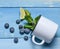 blueberry on mug spill blue background top view mint lime rustic summer