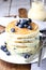 Blueberry pancakes with vanilla syrup on table