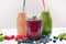 Blueberry, spinachy and orange smoothie on a wooden white background. Glasses of smoothie with berry and mint. Berry, leaf and lim