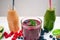 Blueberry, spinachy and orange smoothie on a wooden white background. Glasses of smoothie with berry and mint. Berry, leaf and lim