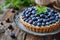 Blueberry tart on a plate, mint garnish, rustic elegance. Fresh fruit dessert