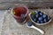 Blueberry tea in a glass cup and fresh blueberries on a burlap cloth on wooden background.Natural herbal beverage.