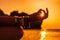 In blur closeup the hand of a young woman in bracelets. Practicing yoga on the beach with sunset. Keeps fingers