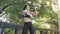 Blur focus technique footage: Asian woman in black sportswear is exercising at the park in summer day.