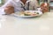 Blur image - Women wear white shirts eating rice in a cafeteria.