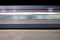 Blur motion of passenger train fast running beside railroad platform