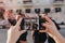 Blur outdoor portrait of girls and boys posing in front of building before party with smartphone in focus. Lady with