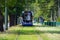 Blur, the tram goes on rails in the alley of trees. eco-friendly urban public transport. urban forestry, protection of the