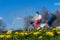 Blur unrecognizable youth, ride bikes. Spring season, green grass meadow, yellow young dandelions, copy space. Abstract