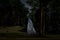 A blur white ghost under big tree in ancient forest