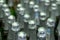 Blurred. Abstract background of bottlenecks with wine or champagne. Rows of bottles in a warehouse or supermarket
