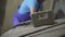 Blurred adult Caucasian man in uniform taking hammer and adjusting equipment on concrete manufacturing site. Male worker