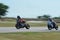 Blurred athletes practicing racing motorcycles on the race track