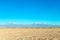 Blurred background of Atacama Desert landscape with snow-capped Andean volcanos, salt flat and some vegetation on horizon, Chile