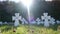 Blurred background, cemetery in summer, many white graves in the green grass.