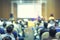 Blurred background of Clouds listening to the Speakers on the stage with Rear view of Audience in the conference hall or seminar