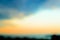 Blurred background of evening sky over a sea in orange and turquoise colors. Twilight sky pastel background